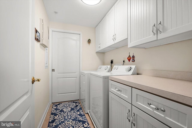 laundry room with washer and clothes dryer, cabinets, and light tile patterned floors