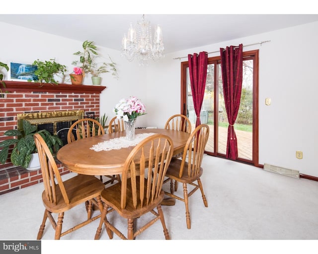 carpeted dining space featuring an inviting chandelier and a brick fireplace