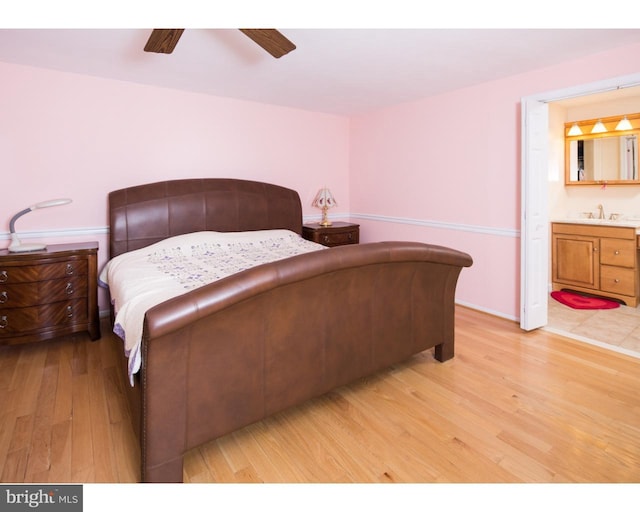 bedroom featuring ensuite bathroom, sink, ceiling fan, and light wood-type flooring