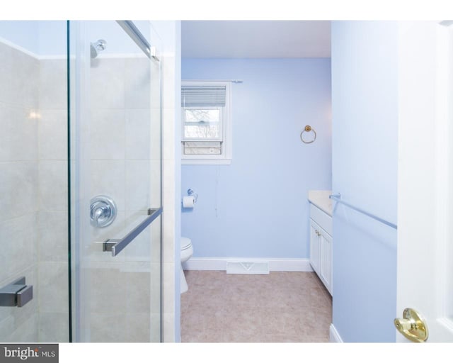 bathroom featuring vanity, an enclosed shower, tile patterned floors, and toilet