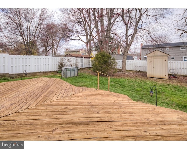 deck with a storage shed and a yard