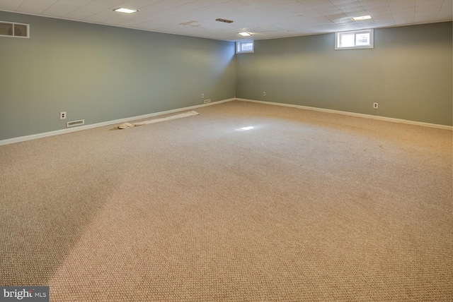 basement with light carpet and a drop ceiling