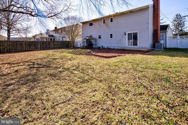 back of house with a yard and central air condition unit