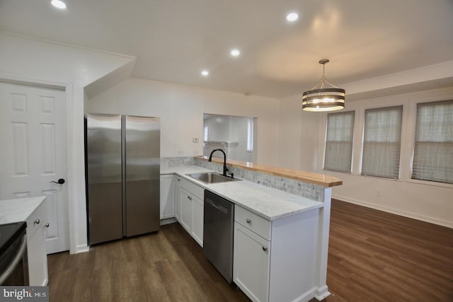 kitchen with kitchen peninsula, stainless steel appliances, sink, decorative light fixtures, and white cabinets