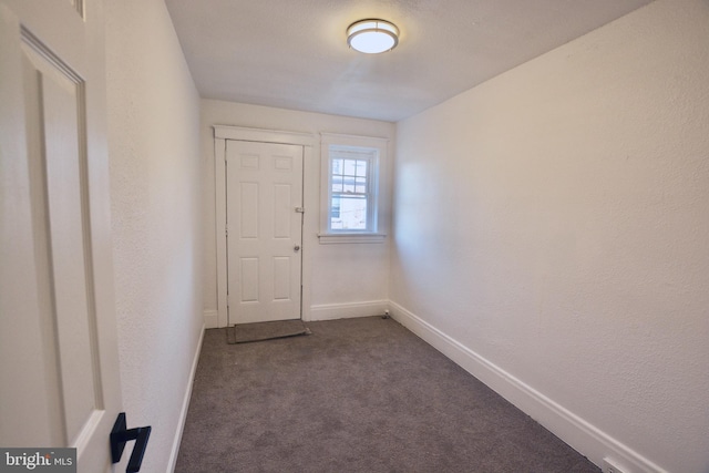 doorway with dark colored carpet