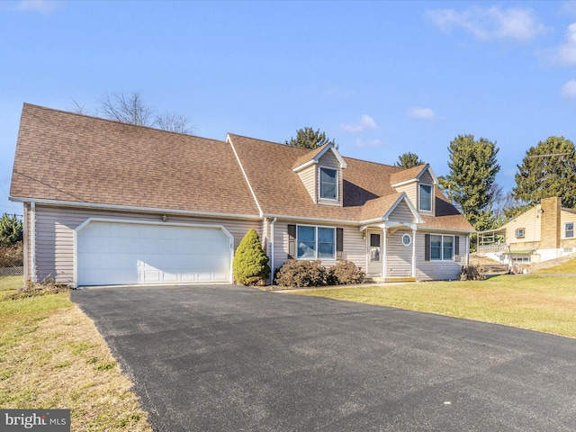 cape cod house featuring a garage and a front yard