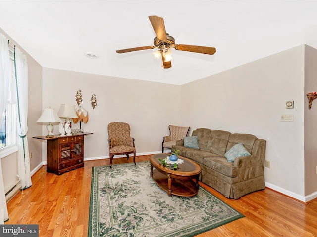 living room featuring light hardwood / wood-style floors, a baseboard radiator, and ceiling fan