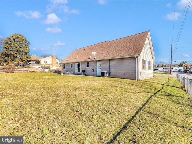 rear view of house with a lawn and central AC