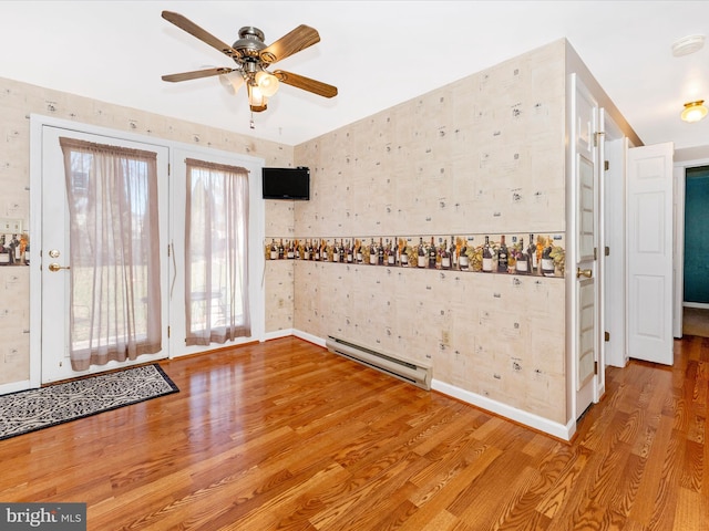 interior space featuring ceiling fan, a baseboard radiator, and hardwood / wood-style flooring