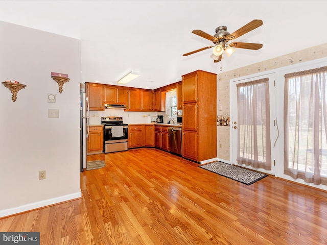 kitchen featuring ceiling fan, sink, light wood-type flooring, and stainless steel appliances