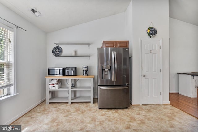 kitchen with lofted ceiling, stainless steel appliances, and light hardwood / wood-style flooring