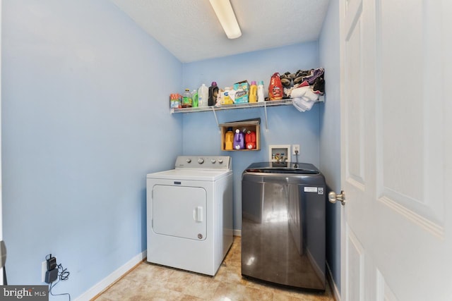 laundry area featuring washer and clothes dryer and a textured ceiling