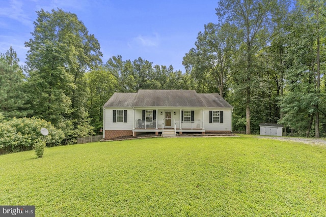 view of front of house with covered porch, a storage unit, and a front yard