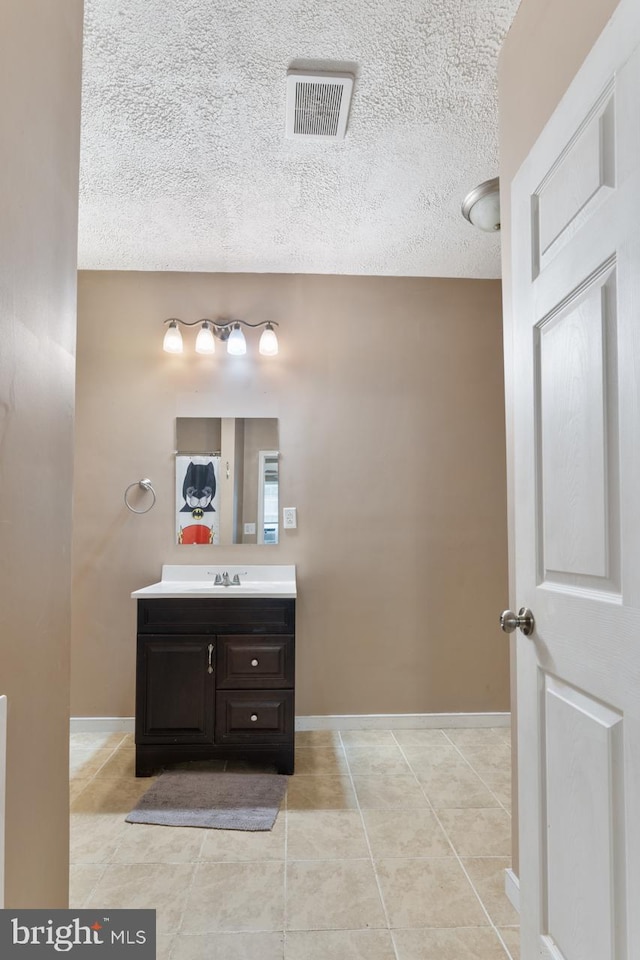 bathroom featuring a textured ceiling, vanity, and tile patterned floors