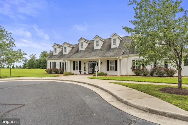 cape cod house with a front yard