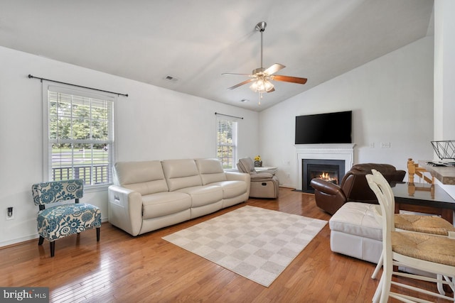 living room featuring ceiling fan, lofted ceiling, and light wood-type flooring