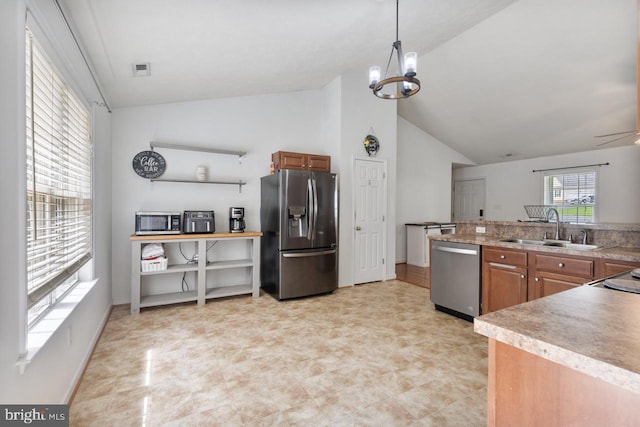 kitchen with pendant lighting, sink, stainless steel appliances, and vaulted ceiling