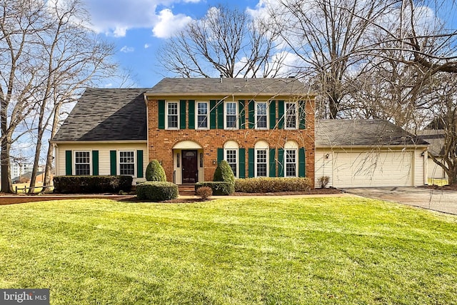 colonial inspired home with a garage and a front yard