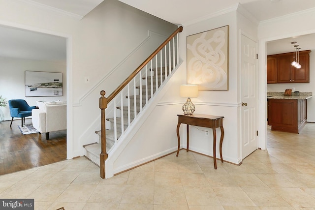 stairway featuring crown molding and tile patterned floors