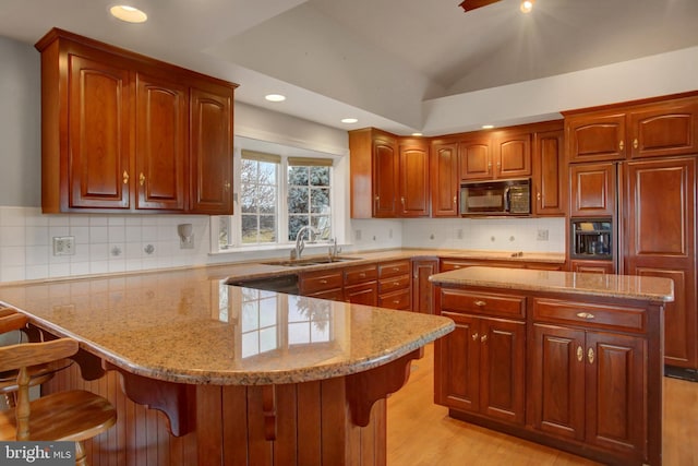 kitchen featuring a kitchen bar, a center island, lofted ceiling, and sink