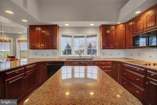 kitchen featuring light stone countertops, sink, black appliances, pendant lighting, and a chandelier