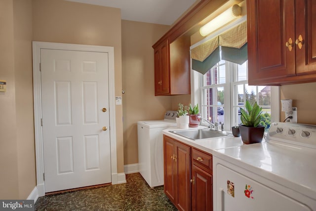 laundry area featuring washer and dryer, cabinets, and sink