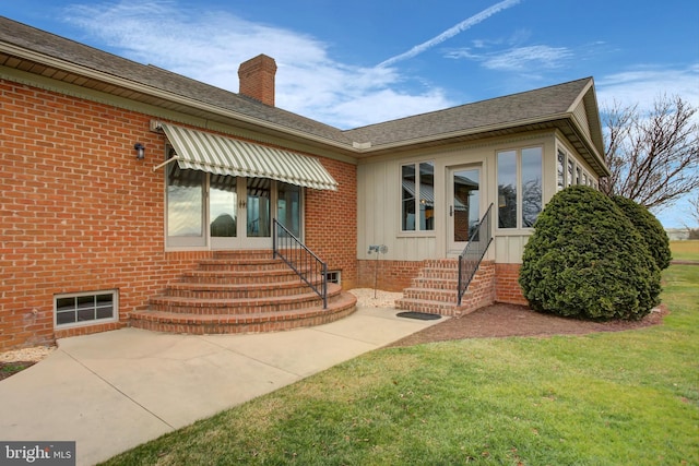 entrance to property featuring a yard