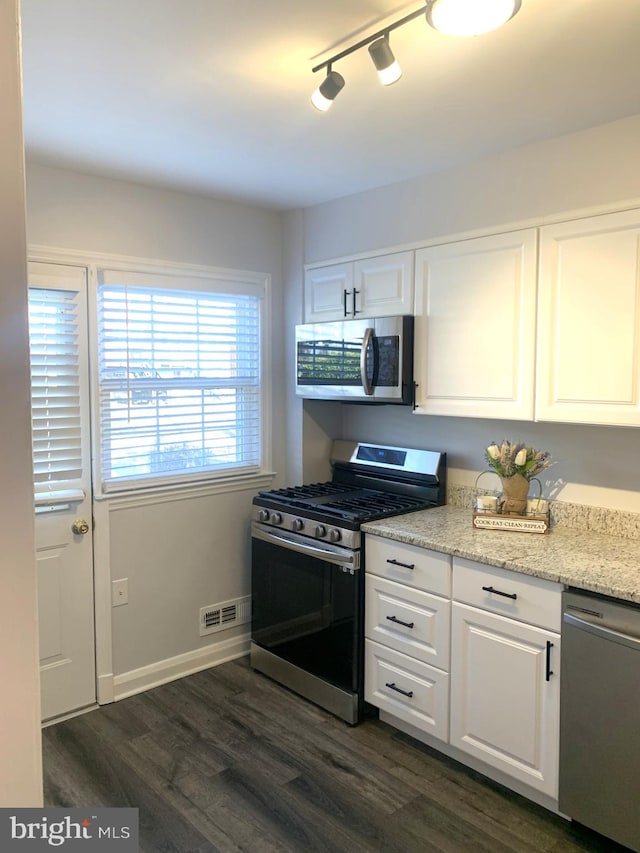 kitchen featuring visible vents, baseboards, appliances with stainless steel finishes, dark wood-style floors, and white cabinets