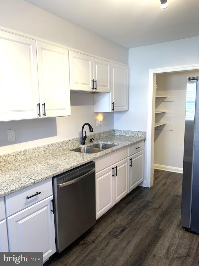 kitchen with a sink, dark wood-type flooring, appliances with stainless steel finishes, and white cabinets