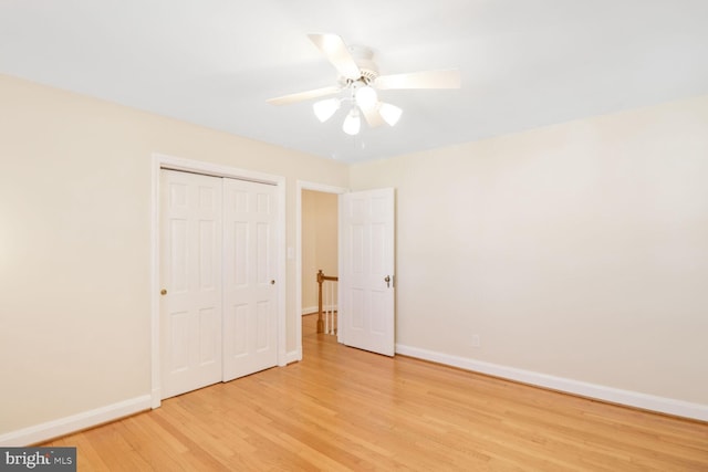 unfurnished bedroom featuring a ceiling fan, light wood-style floors, baseboards, and a closet