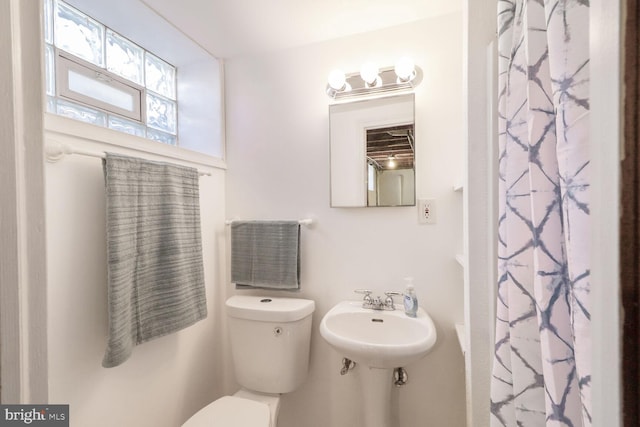 bathroom with a sink, toilet, and a shower with shower curtain