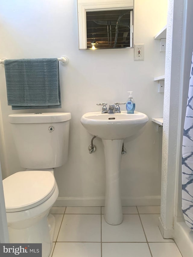 full bath featuring a shower with curtain, tile patterned floors, toilet, and baseboards