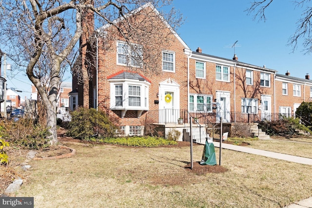 multi unit property featuring a front lawn, brick siding, and a residential view