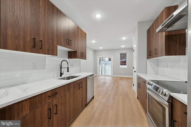 kitchen with sink, tasteful backsplash, ventilation hood, light hardwood / wood-style floors, and appliances with stainless steel finishes