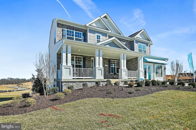 craftsman-style house with a front lawn and covered porch