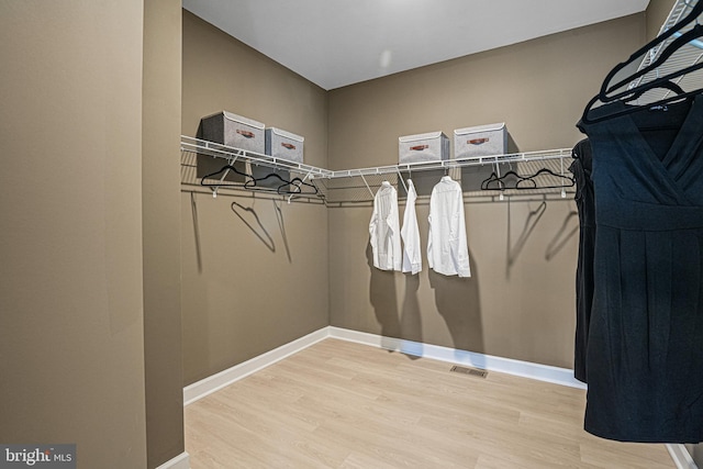 walk in closet with hardwood / wood-style floors