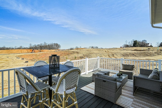 wooden terrace featuring an outdoor living space and a rural view