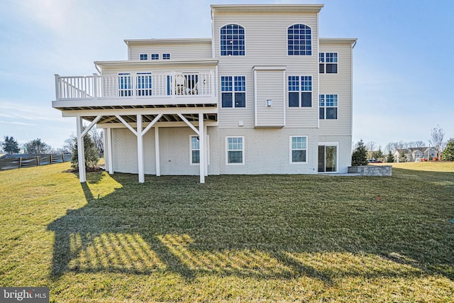 back of property featuring a wooden deck and a lawn