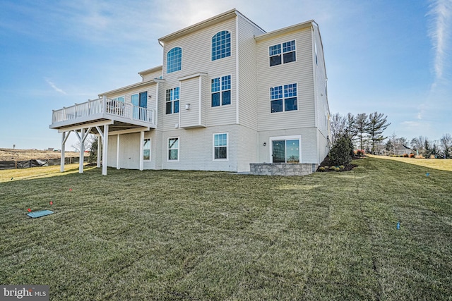 rear view of house with a wooden deck and a yard