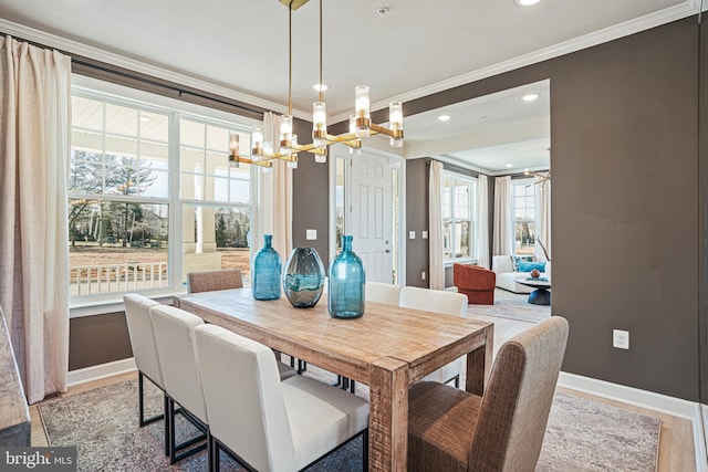 dining area with hardwood / wood-style flooring, crown molding, and a notable chandelier