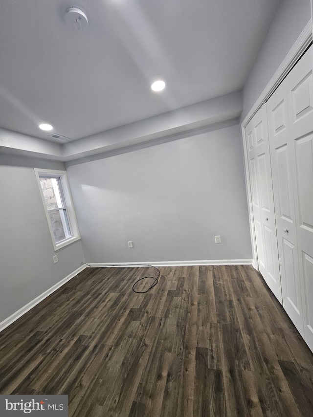 unfurnished bedroom featuring a closet and dark hardwood / wood-style floors