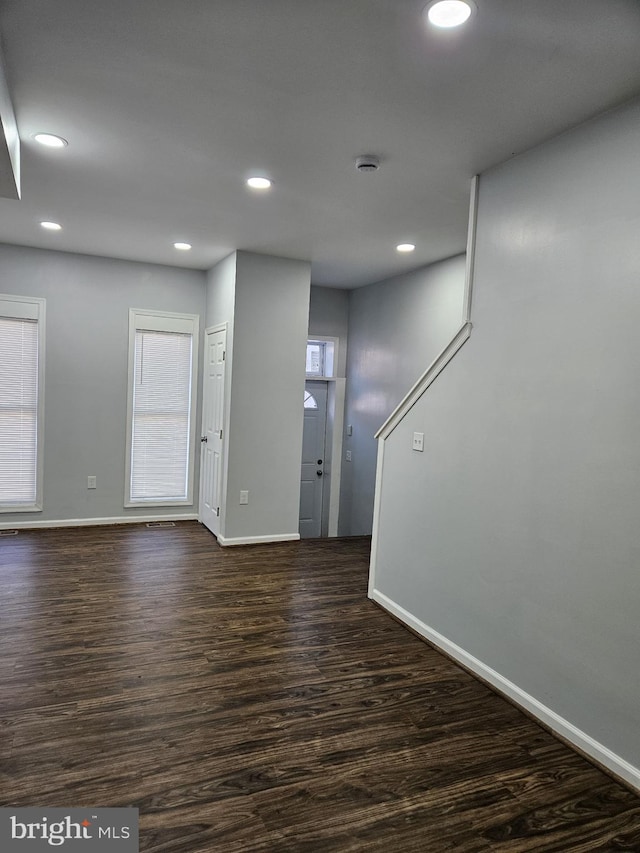 empty room with dark wood-type flooring and plenty of natural light