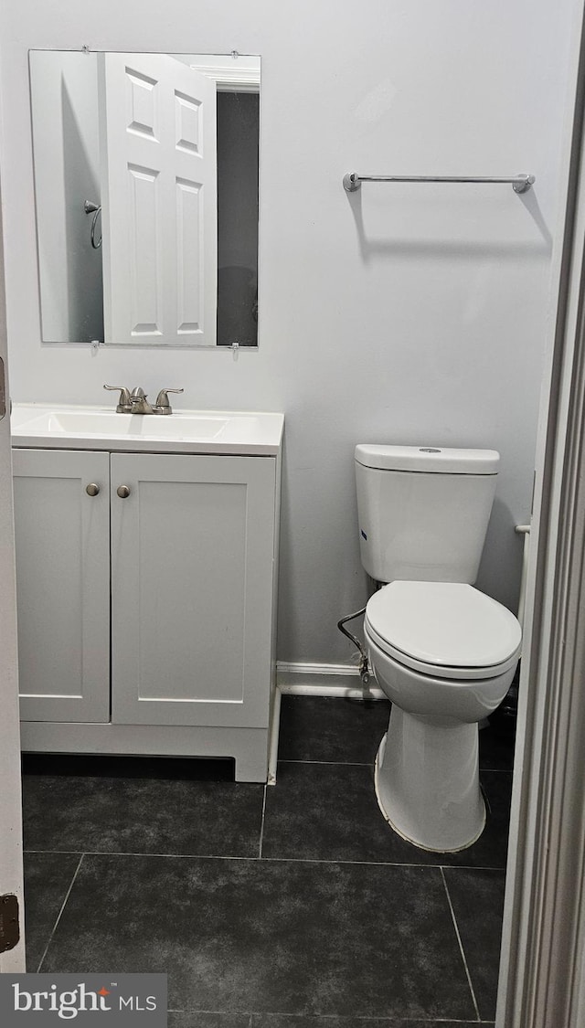 bathroom featuring vanity, tile patterned floors, and toilet