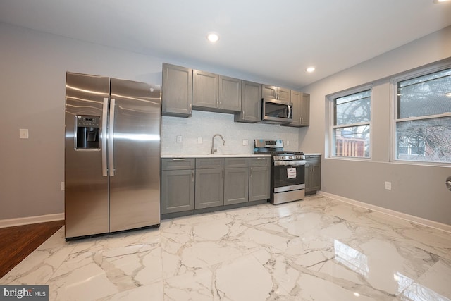 kitchen with gray cabinetry, sink, and appliances with stainless steel finishes