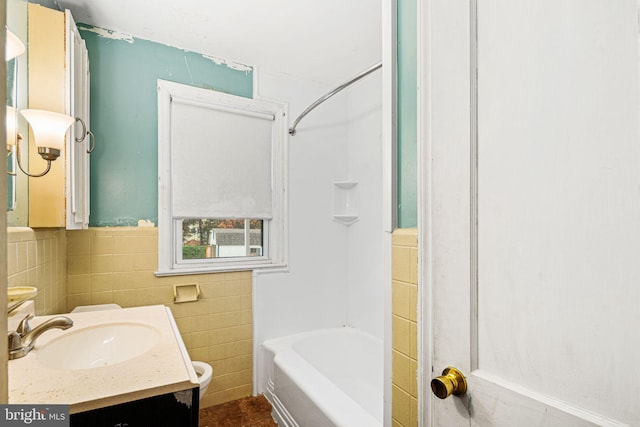 bathroom featuring vanity, tub / shower combination, and tile walls