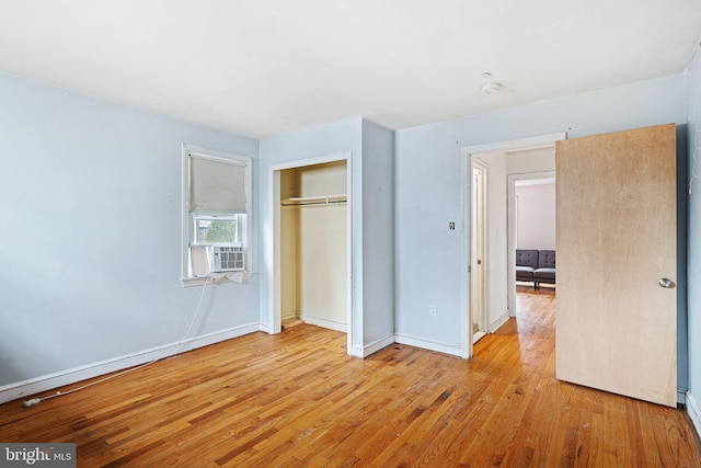 unfurnished bedroom with light hardwood / wood-style flooring and a closet