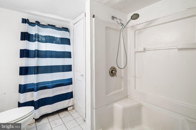 bathroom featuring tile patterned floors, toilet, and walk in shower