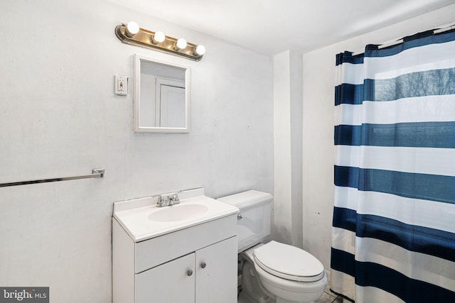 bathroom with a shower with shower curtain, vanity, and toilet