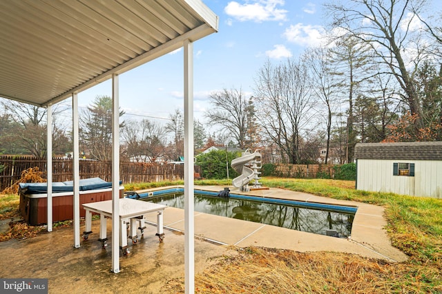 view of swimming pool featuring a shed and a hot tub