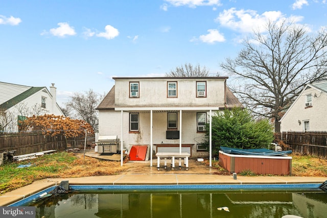 rear view of house with a hot tub